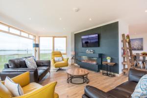 a living room with couches and a tv and a fireplace at Gualan Sands in Clachan