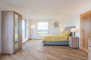 Gualan Sands في Clachan: غرفة نوم بسرير وبطانية صفراء ونافذة