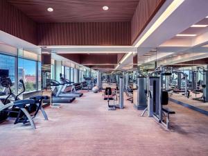 a gym with a lot of treadmills and machines at Grand Mercure Jakarta Harmoni in Jakarta