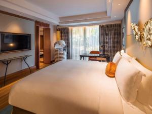 a bedroom with a large bed and a living room at Sofitel Singapore Sentosa Resort & Spa in Singapore