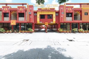 un bâtiment rouge et jaune avec beaucoup de fenêtres dans l'établissement RedDoorz @ Golden Victory Hotel Mabalacat Pampanga, à Mabalacat