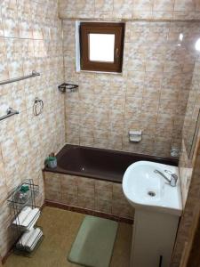 La salle de bains est pourvue d'un lavabo et d'une baignoire. dans l'établissement Apartament Centrale, à Orăştie