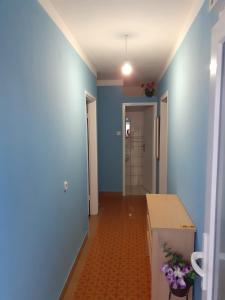 einen Flur mit blauen Wänden und ein Zimmer mit einem Tisch in der Unterkunft City Apartment Damir in Makarska