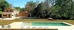a backyard with a swimming pool and a house at Recientemente restaurada, ideal para familias! in Cabanellas