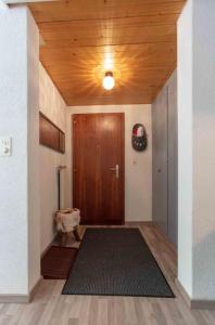 - un couloir avec une porte en bois et un tapis dans l'établissement Grand Studio au centre de Crans, à Crans-Montana