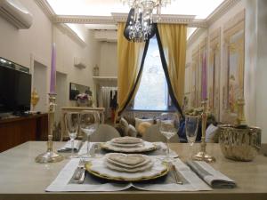 tavolo da pranzo con piatti e bicchieri da vino di The Right Place 4U Roma Savelli Boutique Apartment a Roma