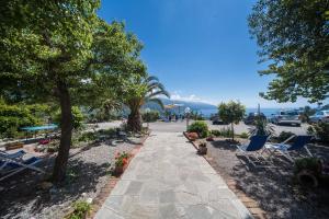 a walkway in a park with chairs and trees at Albergo Suisse Bellevue in Monterosso al Mare