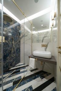 a bathroom with a sink and a glass shower at Hotel Cala Moresca in Bacoli