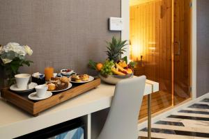 a breakfast table with a tray of fruit and juice at Hotel Cala Moresca in Bacoli