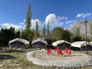 a group of red chairs in front of some tents at Hotel Nubra Delight and Camps in Hundar