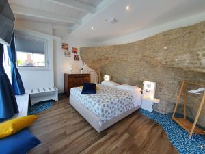 una camera con letto e parete in pietra di b&b Dea Fortuna a Bacoli