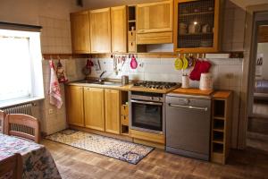La cuisine est équipée de placards en bois et d'un four avec plaques de cuisson. dans l'établissement Sula's Apartment, à Spormaggiore