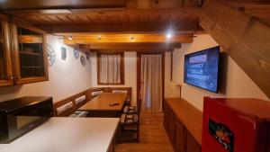 a kitchen with a counter and a tv on the wall at La Casa Degli Orsi - presso Sussy Residence in Falcade