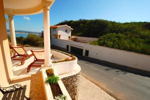 a balcony with two chairs and a view of the ocean at Lighthouse - House with amazing sea views in São Martinho do Porto