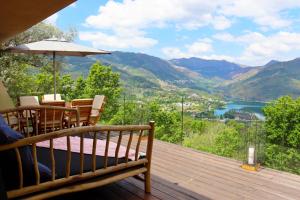 eine Holzterrasse mit Tisch und Sonnenschirm in der Unterkunft Casa do Tempo Gerês by Gerês Casas in Vieira do Minho