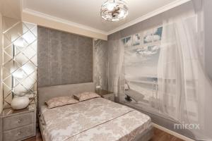een slaapkamer met een bed en een raam bij Utra Center Beste apartment city view in Chişinău