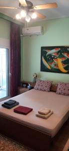 Stylish apartment close to Rafina port في رافينا: غرفة نوم بسرير كبير عليها مناشف
