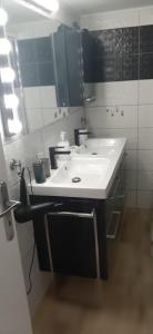 Stylish apartment close to Rafina port في رافينا: حمام مع حوض أبيض ومرآة