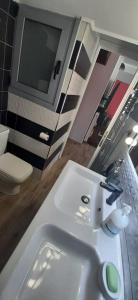 a bathroom with a white sink and a tv at Stylish apartment close to Rafina port in Rafina