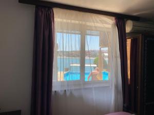 a bedroom with a window with a view of a pool at Villas Sozopol in Sozopol