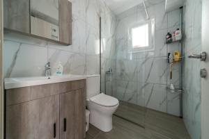 uma casa de banho com um WC, um lavatório e um chuveiro em Amazing New Apartment in Skala em Skála Kefalonias