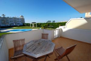 een houten tafel en 2 stoelen op een balkon bij Turtle - 3 bedroom apartment in Nazaré with 2 shared pools and private terrace in Nazaré