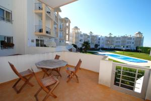 balcón con mesa, sillas y piscina en Turtle - 3 bedroom apartment in Nazaré with 2 shared pools and private terrace, en Nazaré