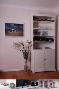 una habitación con un armario blanco con una planta en Sonnenschein, en Wenningstedt