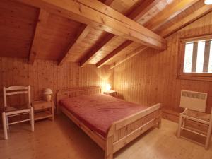 a bedroom with a bed and a chair in a room at Chalet Morillon Village, 3 pièces, 7 personnes - FR-1-642-42 in Morillon