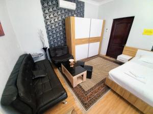 Un dormitorio con una cama y una silla de cuero negro en ApartHotel RioNi, en Kutaisi