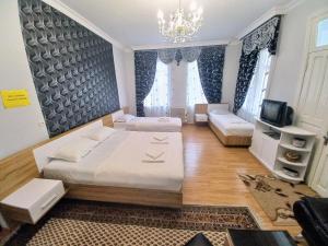 Un dormitorio con una cama grande y una lámpara de araña. en ApartHotel RioNi, en Kutaisi
