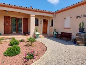 una casa con un banco y un barril en Aux Trois Mûriers, en Villeneuve-sur-Lot