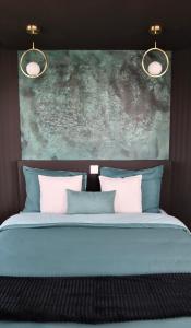 łóżko z niebiesko-białymi poduszkami i obrazem w obiekcie Appart- hotel Love Room YSCHOOL w Troyes