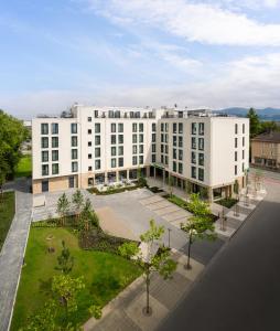 uma vista aérea de um edifício branco com um pátio em Holiday Inn Express - Rosenheim, an IHG Hotel em Rosenheim