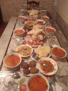 een lange tafel met veel borden eten erop bij guest house "BETQIL" adishi in Adishi