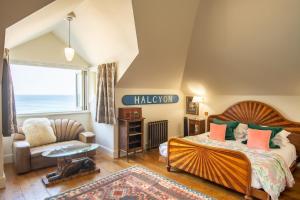 a bedroom with a bed and a couch and a window at Tolcarne Beach Colonial Restaurant and Rooms in Newquay