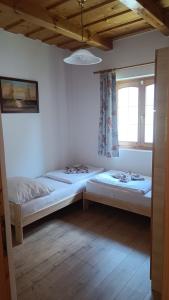 two beds in a room with a window at Vica Apartman in Balatonberény