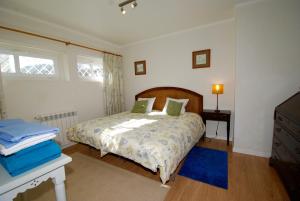 a bedroom with a bed and a table and a window at Seashell - House with private pool and garden in São Martinho do Porto