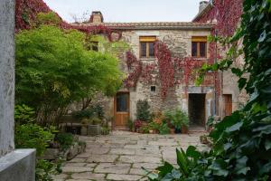an external view of a stone house with ivy at Casa Rural Caenia Grupos in Traguntia