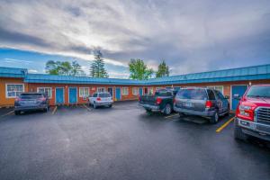 a parking lot with cars parked in front of a motel at Royal Gateway Motel by OYO in Bend