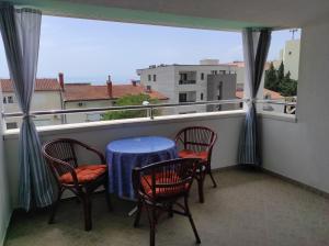 balcón con mesa, sillas y ventana en Apartments Marija, en Makarska