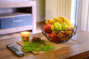 uma taça de fruta numa mesa com um comando à distância em The White Horse Apartmens em Borovets