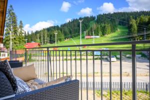 um banco numa varanda com vista para uma estrada em The White Horse Apartmens em Borovets