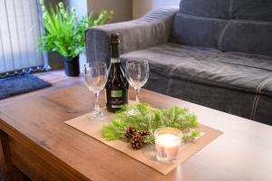 a bottle of wine and two glasses on a coffee table at The White Horse Apartmens in Borovets
