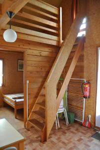 a wooden staircase in a room with a bed at Camping de Bourbon-lancy in Bourbon-Lancy