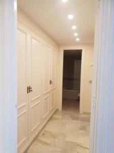 a hallway with white cabinets and a toilet in a room at Ático - Edificio Marina Banús- Calle Muelle de Ribera in Marbella