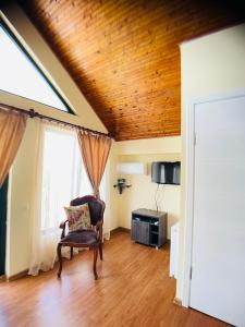 sala de estar con silla y techo de madera en Hotel Tramonto en Chakvi