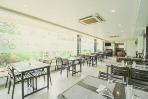 a restaurant with tables and chairs and a large window at White Pearl Residency in Pondicherry