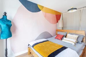 sypialnia z łóżkiem i ścianą z parasolami w obiekcie Paradis - Piscine Privée w mieście Dinan +5 zdjęć