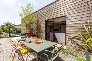 patio na dziedzińcu ze stołem i krzesłami w obiekcie Paradis - Piscine Privée w mieście Dinan